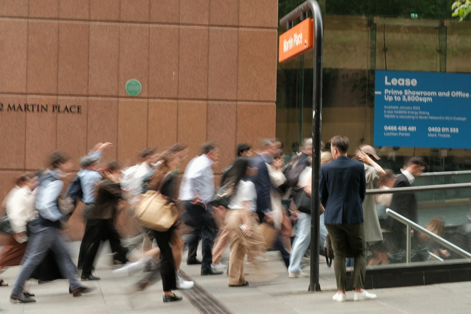 A group of people walking down a street next to a building